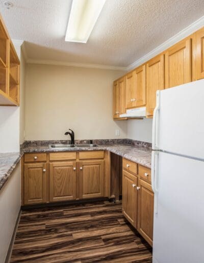 Open, unfurnished carpeted living area with view of kitchen